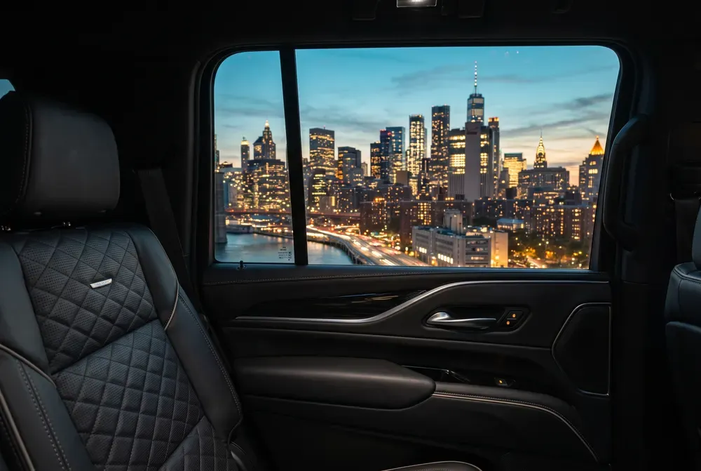 Manhattan skyline at dusk seen from the rear cabin of a Cadillac Escalade
